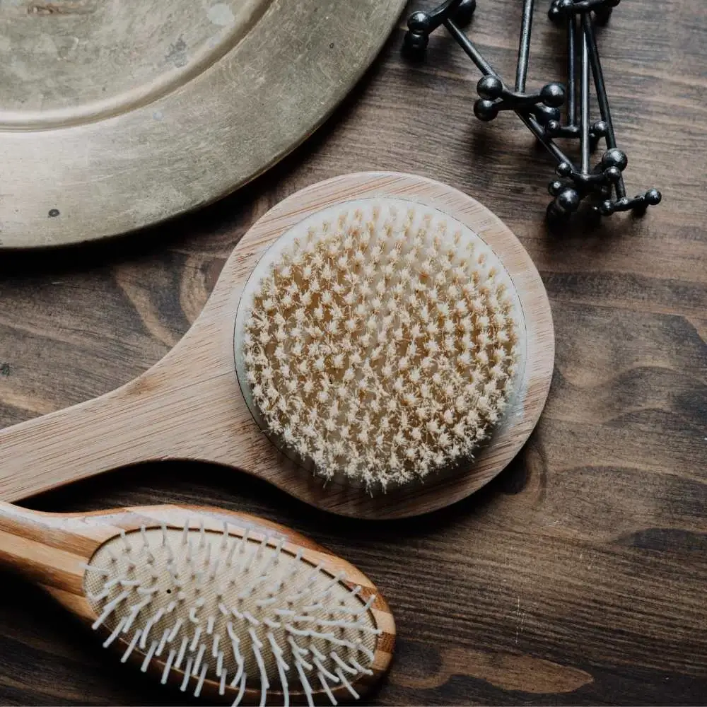 Close-up of a 4C hair detangling brush in a bathroom setting