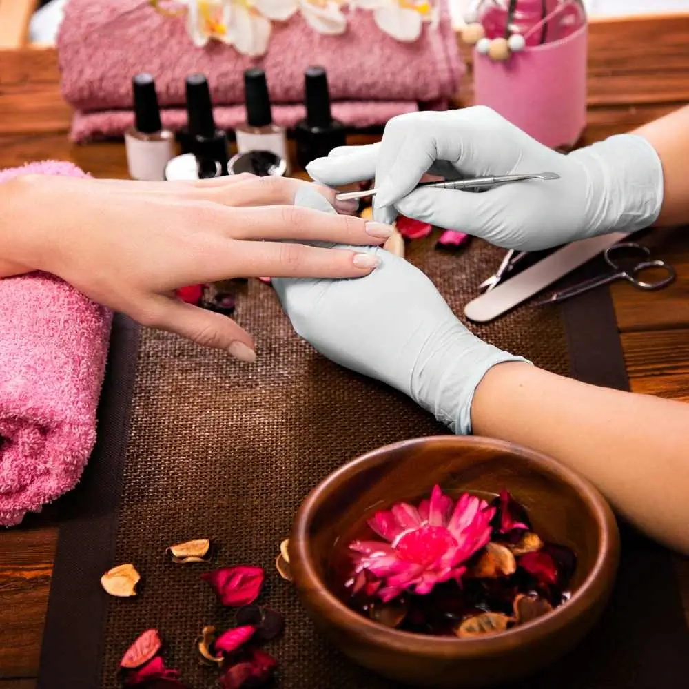   nail technician with nail care tools doing manicure 