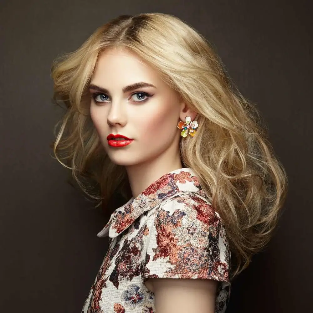 blonde woman with red lips wearing flower earrings