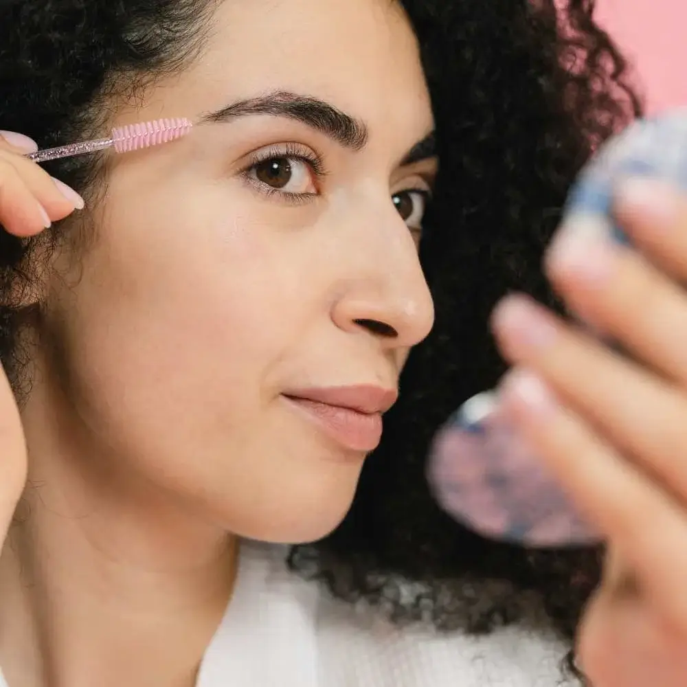 A woman flawlessly applying the best clear eyebrow gel