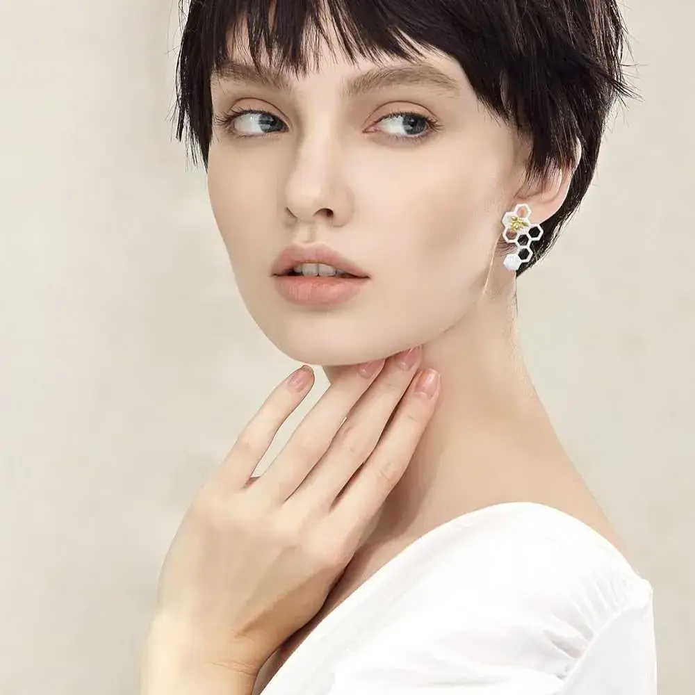 portrait  of a beautiful young woman with short black hair wearing honeycomb earring