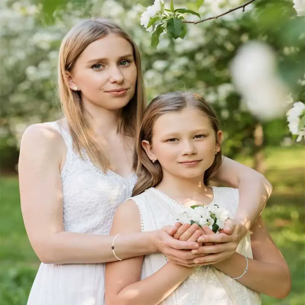 mother and daughter in white dress wearing white photo projection bracelets