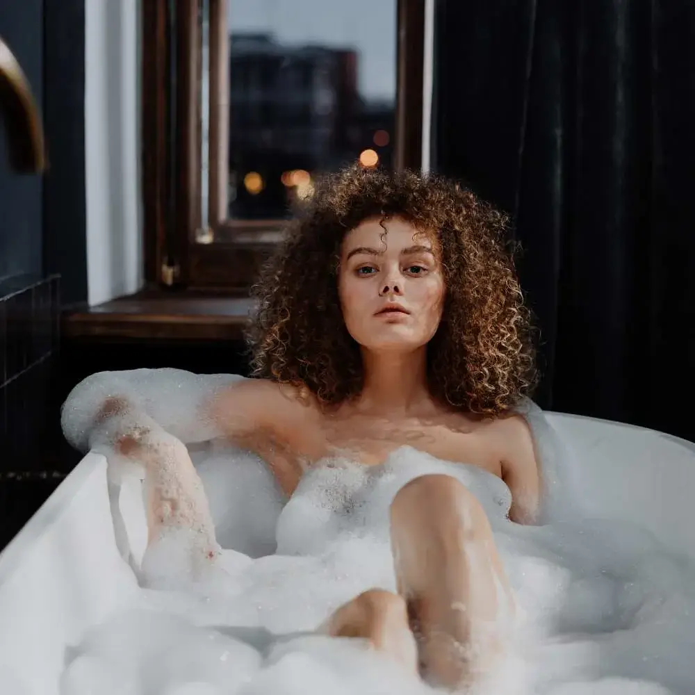 Woman relaxing in a bubble bath filled with lavender body wash