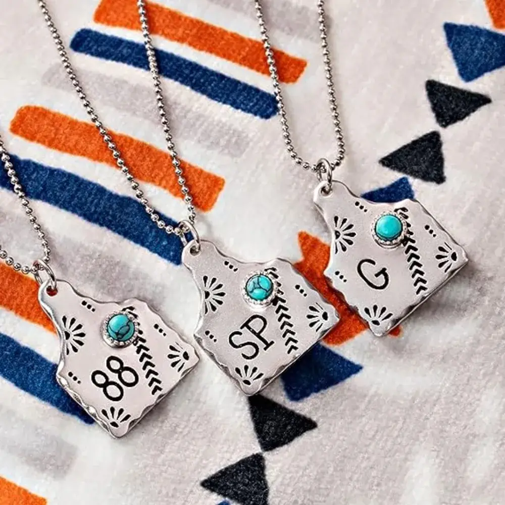 three cow tag necklaces on a fabric