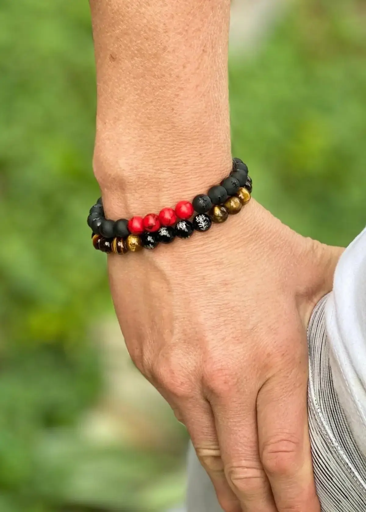 What materials are commonly used to make Red and Black Bracelets?